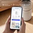 Filter replacement management app on phone beside Levoit air purifier