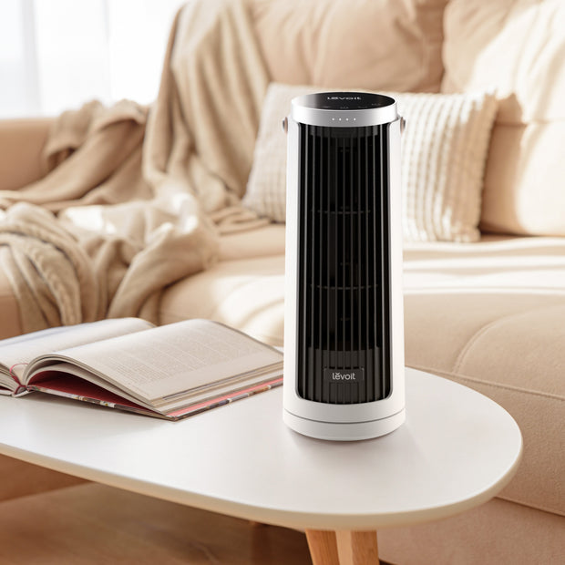 Mini tower fan on side table, white body with black vertical grille
